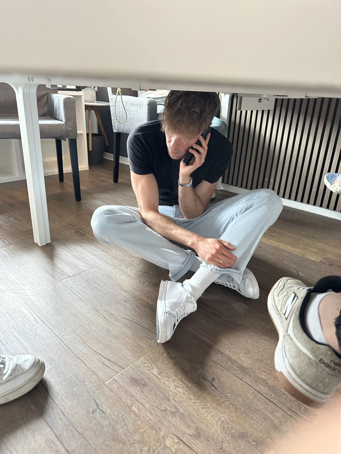 Ein Mann telefoniert unter einem Besprechungstisch