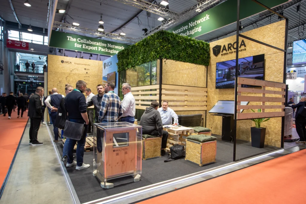 ARCA-Messestand mit Holzgestaltung, Exponaten und Gesprächsbereich